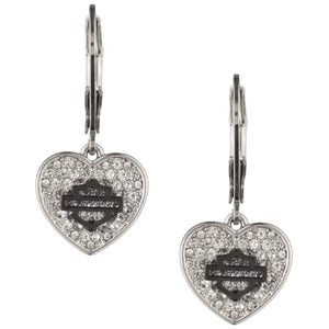 A pair of silver heart-shaped dangle earrings with clear pavé stones and a central black Harley-Davidson bar logo, shown on a plain white background.