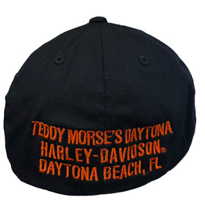 A black baseball cap featuring orange embroidered text that reads 'TEDDY MORSE'S DAYTONA HARLEY-DAVIDSON DAYTONA BEACH, FL'.