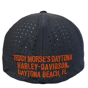 A black perforated baseball cap featuring orange embroidered text that reads 'TEDDY MORSE'S DAYTONA HARLEY-DAVIDSON DAYTONA BEACH, FL'.