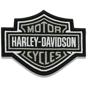 Harley-Davidson embroidered patch in the brand's classic bar-and-shield logo, featuring black, white, and gray colors on a plain white background.