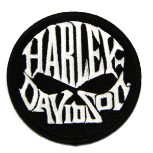 A circular black embroidered patch featuring the Harley-Davidson logo in stylized white lettering, isolated on a plain white background.