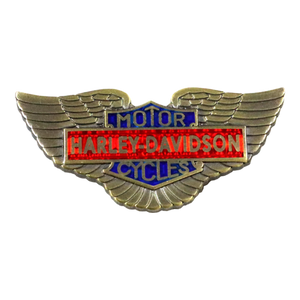 A Harley-Davidson wings logo pin or badge with gold-tone metal wings, a red center bar, and blue enamel sections reading 'MOTOR' and 'CYCLE'.