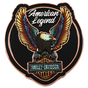 A Harley-Davidson American Legend enamel pin featuring a bald eagle with colorful wings on a black shield-shaped background with a copper border.