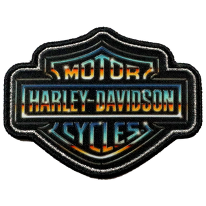 An embroidered Harley-Davidson patch featuring the classic bar and shield logo with a black border and a vibrant gradient of orange, yellow, blue, and teal lettering on a white background.
