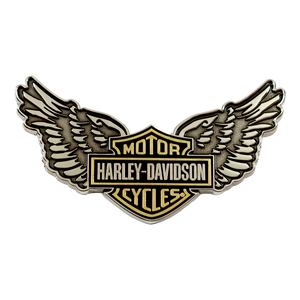 A Harley-Davidson wings logo pin or badge on a plain white background. The design features the classic Harley-Davidson bar and shield in gold and black, with large silver and black wings extending from the sides.