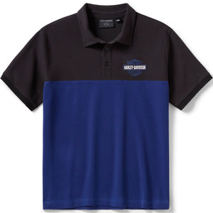 A colorblock short-sleeve polo shirt with a black upper body and collar, and a royal blue lower body. The left chest features a small embroidered Harley-Davidson logo.