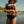 Person wearing a black bikini with Harley-Davidson logos by a body of water.