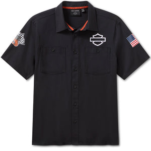 Black short-sleeve shirt with brand logo and patches on a white background