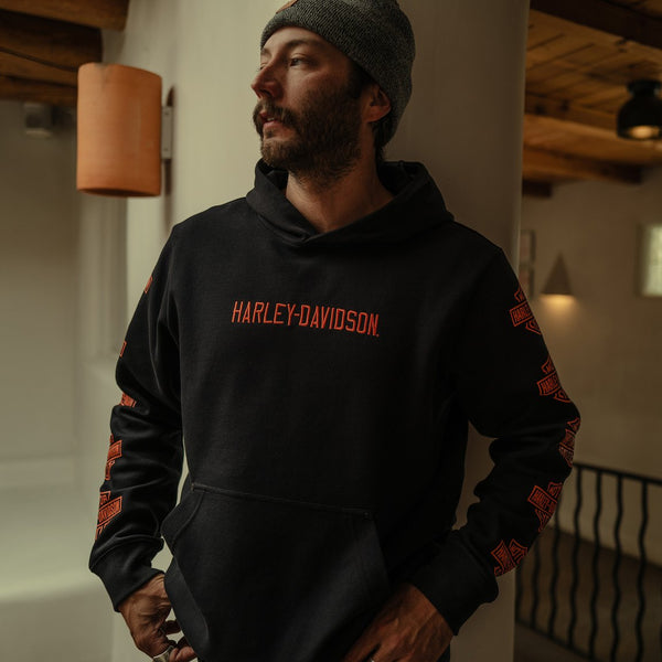 Man wearing a black Harley-Davidson hoodie indoors.