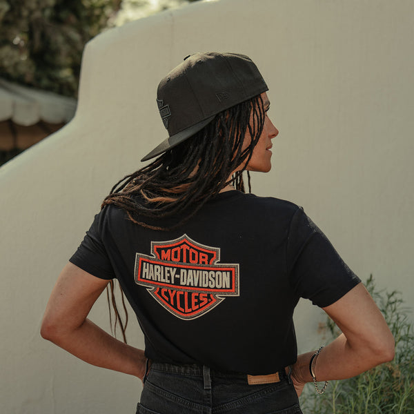 Person wearing a black Harley-Davidson t-shirt with a logo on the back.