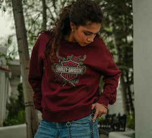 Person wearing a maroon Harley-Davidson sweatshirt outdoors.
