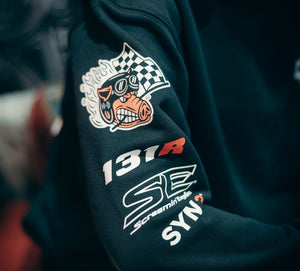 Close-up of a dark blue jacket with racing-themed graphics and text.