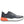 Gray athletic shoe with orange sole on a white background