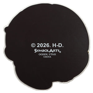 A black die-cut sticker shaped like a cartoon character's head, featuring white text that reads '© 2026. H-D.