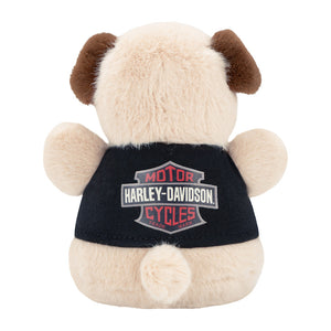 A plush toy dog shown from the back, with cream-colored fur, brown ears and ears, and a black shirt featuring the Harley-Davidson Motor Cycles logo.