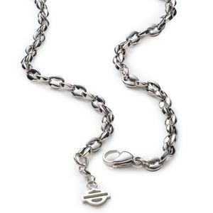 A silver-toned metal chain necklace with a small dangling Harley-Davidson logo charm, displayed on a clean white background.