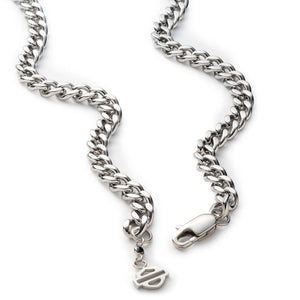 A silver-toned metal curb chain necklace with a lobster clasp and a small dangling logo charm, shown on a plain white background.