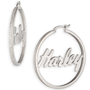A pair of silver hoop earrings on a plain white background. One earring is shown from the side, featuring a textured silver band with the name 'Harley' in script engraved on the front.