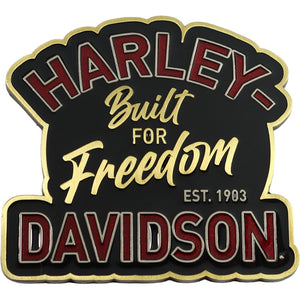 A Harley-Davidson themed sign or emblem with a black background, gold border, and red-and-gold lettering that reads 'HARLEY Built FOR Freedom DAVIDSON EST. 1903' on a plain white background.