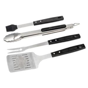 Four-piece barbecue tool set with stainless steel blades and black handles, including a spatula, turner, brush, and fork, on a white background.