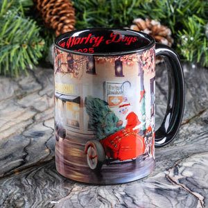 Mug with a printed design of a red motorcycle and Christmas tree, placed on a marble surface with greenery in the background.