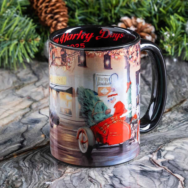 Mug with a printed design of a red motorcycle and Christmas tree, placed on a marble surface with greenery in the background.