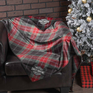 Plaid blanket with Harley-Davidson logo draped over a chair next to a Christmas tree.