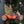 Decorative ornament of Santa Claus on a motorcycle with a Christmas tree, against a blurred Christmas tree background.