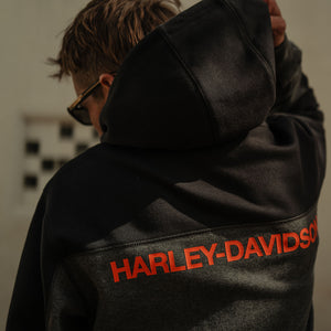 Person wearing a black Harley-Davidson hoodie with red text.