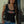 Woman wearing a black tank top with a Harley-Davidson flames blinged, standing
