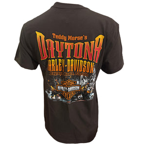 A dark brown short-sleeve t-shirt shown from the back, featuring a large graphic print with 'Teddy Morse's Daytona Harley-Davidson' in red, orange, and yellow lettering, and a classic Harley-Davidson logo at the bottom.